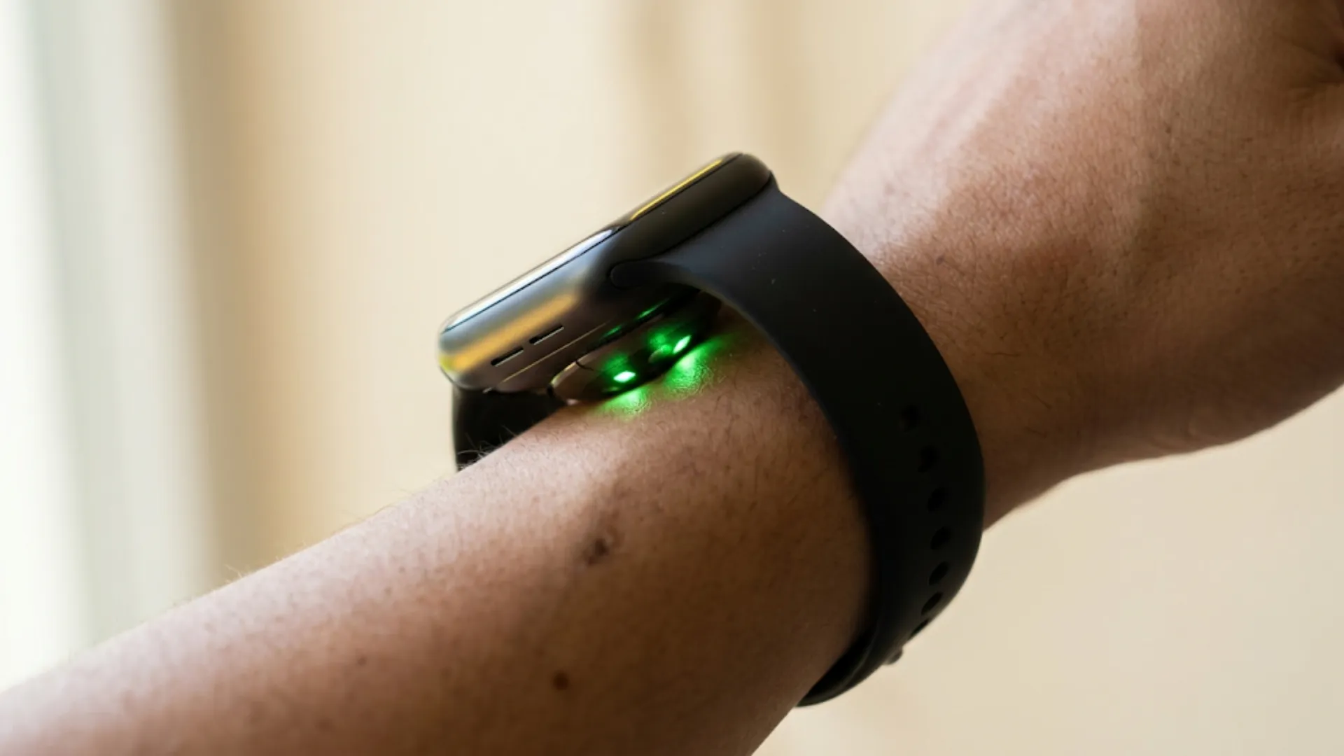 Sensor óptico de smartwatch no pulso emitindo luz verde — wearables para autoconhecimento e dados de saúde